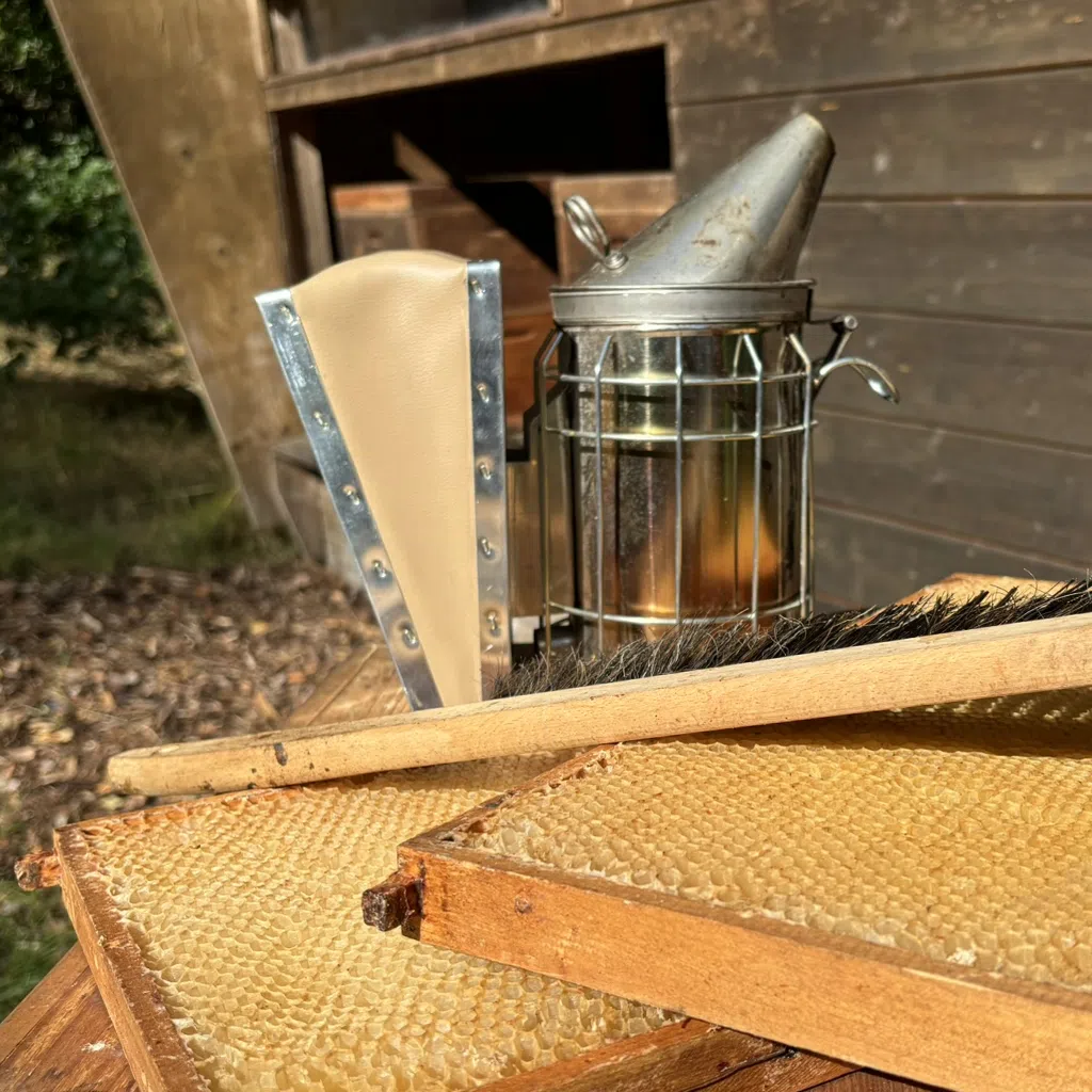 Imker-Ausrüstung auf Bienenbeute vor Bienenhaus